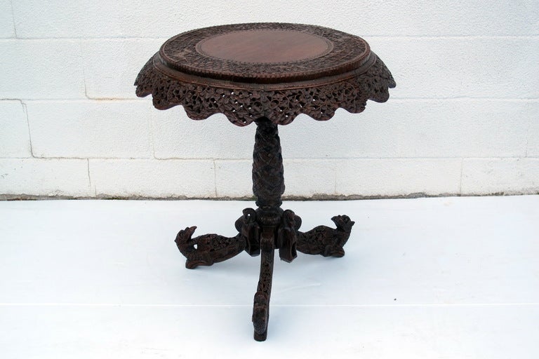 A intricately hand carved pedestal side table from India