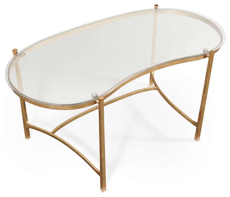 Contemporary iron framed kidney shaped desk with antiqued gilded finish and a shaped clear glass writing surface. Please contact us for availability.