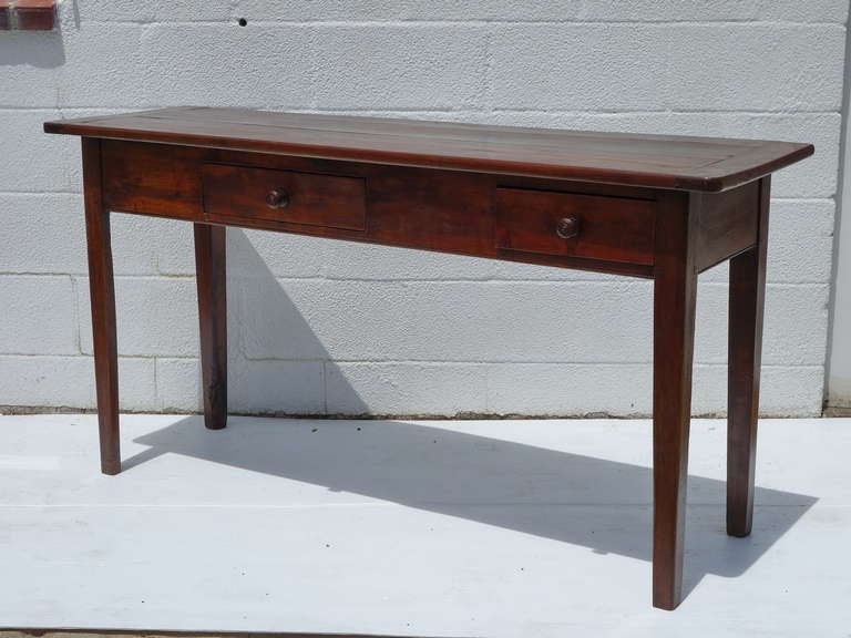 A French 19th C simple serving table with tapered legs, bread board ends and two drawers. Pine, with dark stained finish
