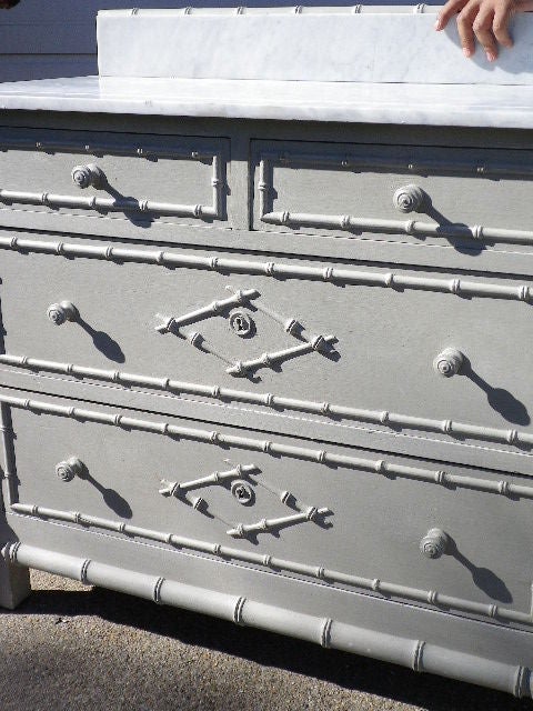 A painted Chest of Drawers with a marble top and splashback.