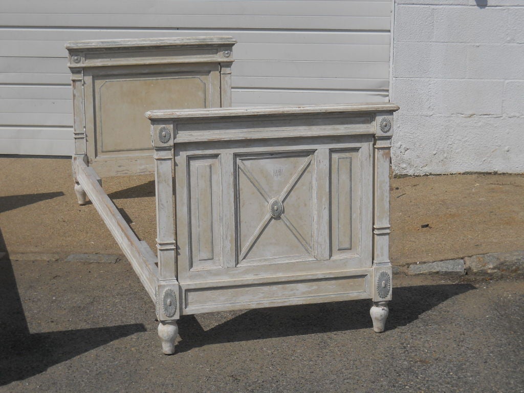 Pair of French Single beds in the Directoire Style. Original paint still remains. Lovely pale grey color. Original bolts and siderails. Sold as a pair