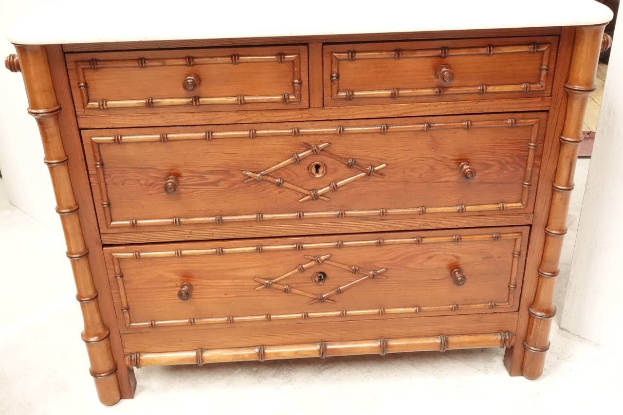 A French faux bamboo chest of drawers with original marble top, hand towel rail at either end, circa 1920.