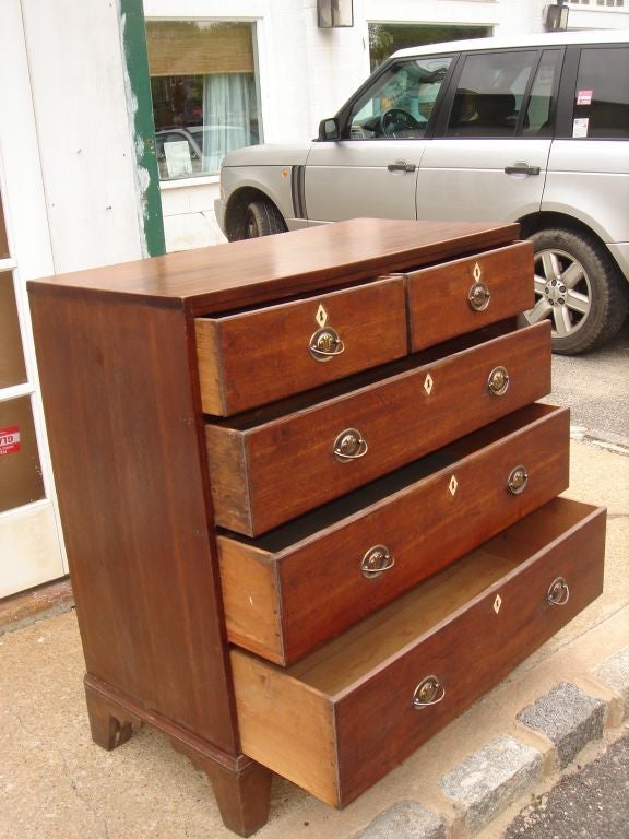 English 5 drawer chest with decorative ivory key holes and antique brass hardware.