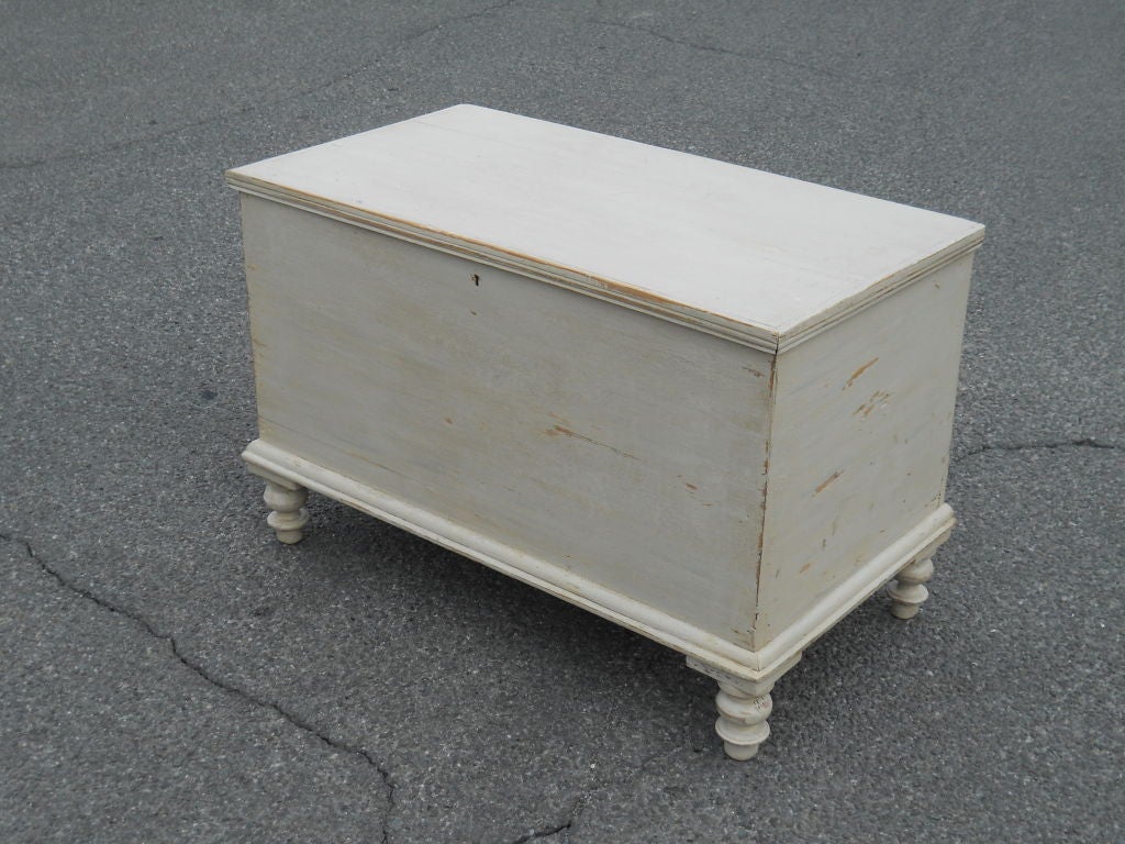 English pine trunk on turned feet, repainted in ivory color.