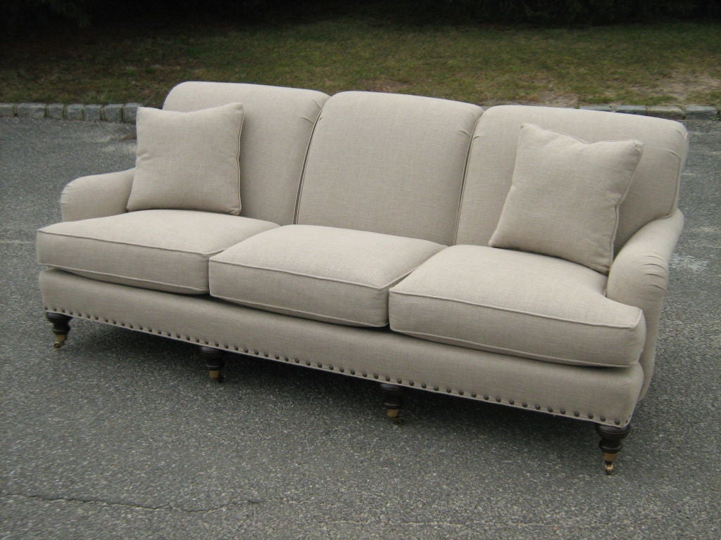 Three cushion Bridgewater tight back sofa with exposed turned front legs on castors. Optional comfort down cushions and nailhead detail. Can be ordered in a range of fabrics or COM. 
Please contact us for current pricing and availability.