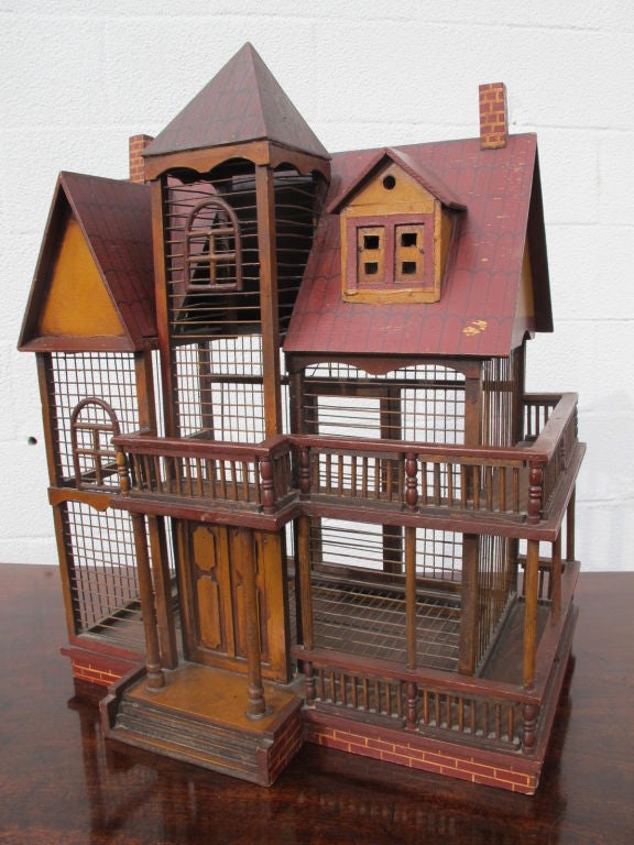 A turn of last century French handmade and hand painted birdcage in the form of a village house