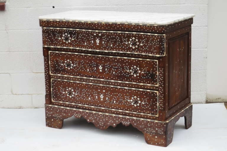 A vintage inlaid Syrian chest of three drawers with marble top..mother of pearl and camel bone inlay with Carrara marble top. 
C 1980