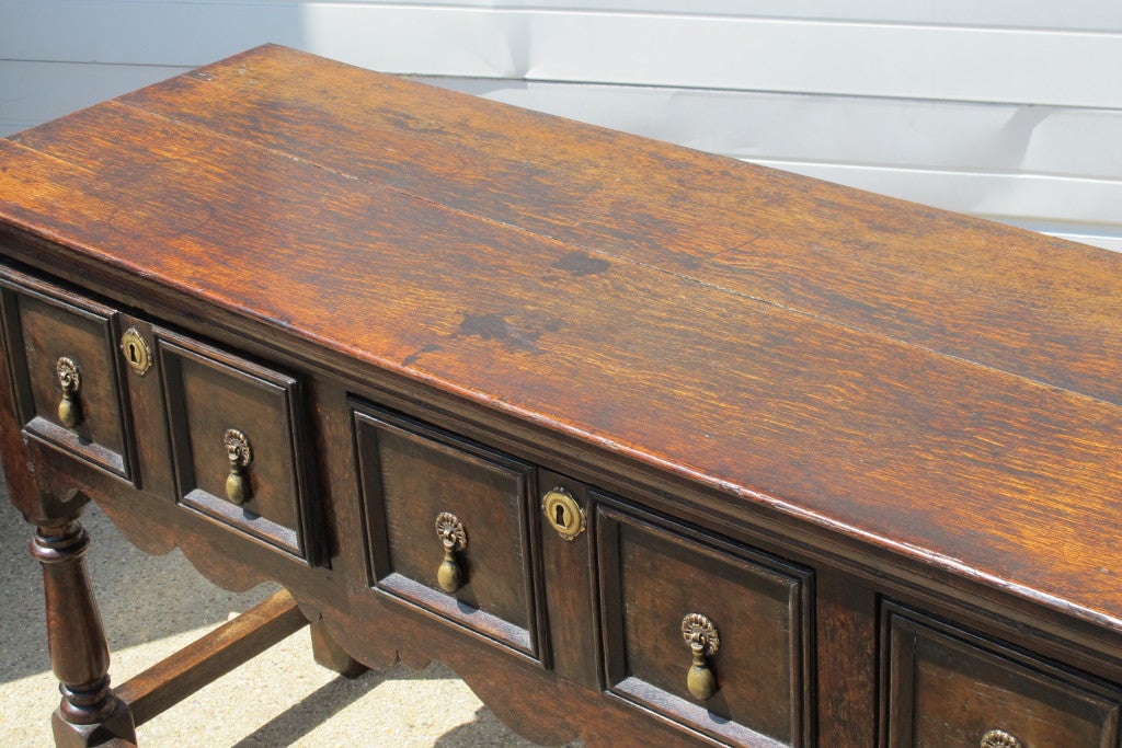 An English Oak Server Base, with six drawers and original brass hardware. Decorative handncarved front skirt.