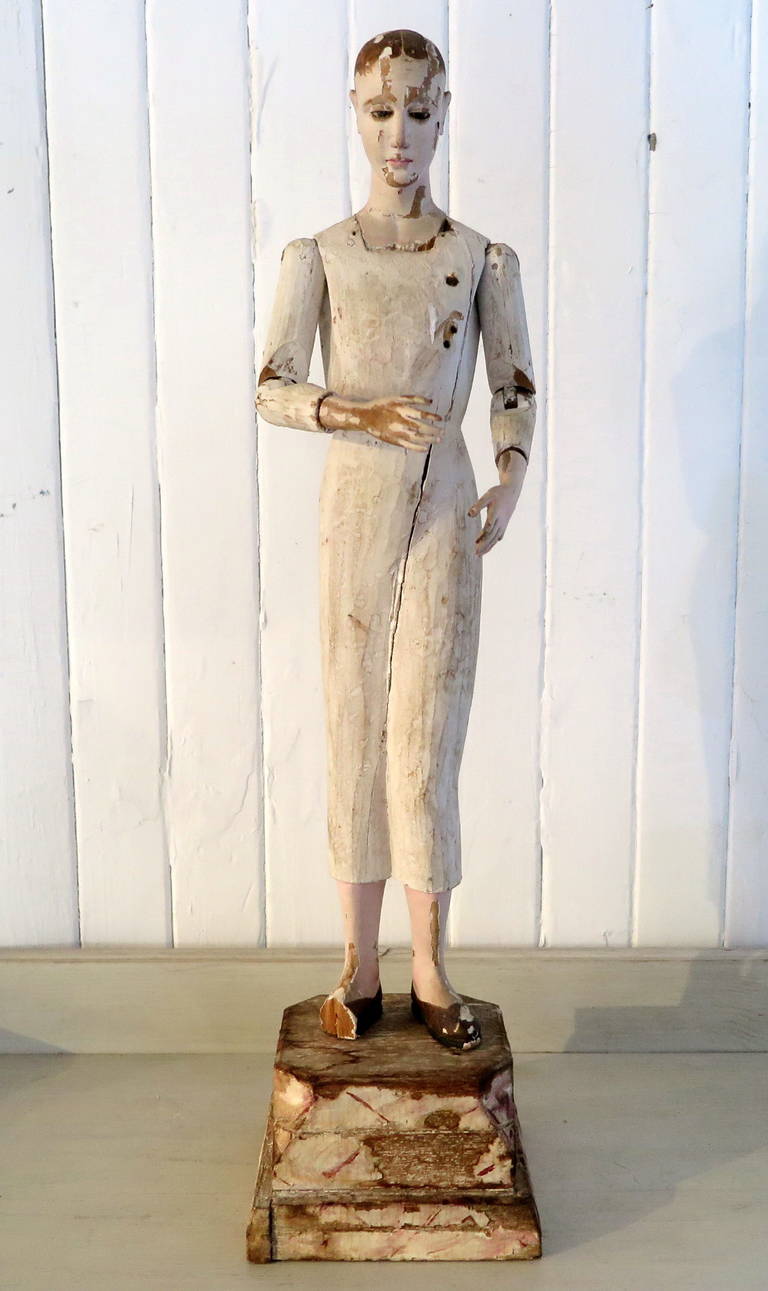 A 19th century Santos Figure, on original stand. Remains of original paint. Articulated arms, shoulders, and removable head. Slight damage to foot, could be repaired.