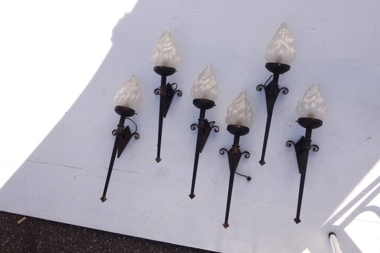 Six cast iron torchiere sconces with frosted glass shaped like flames. Please contact for current availability.