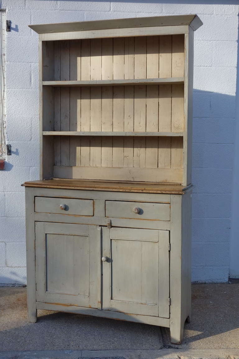 Narrow painted English pine kitchen dresser or hutch, in two parts.  Circa 1890.