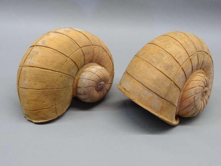 Two snail form garden ornaments, one full round and the other half round, executed in terracotta. The full round measuring 13" wide x 9" deep x 10.25" high overall and the half-round measuring 12.5" wide x 10" deep x