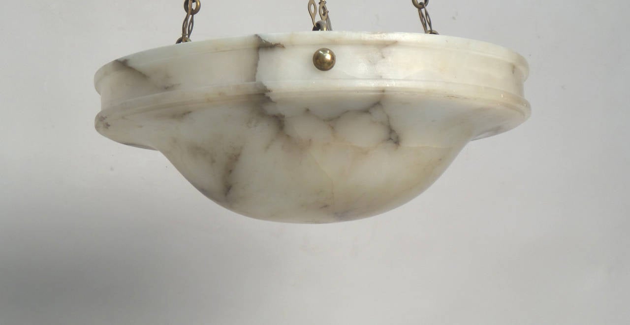 A circular alabaster ceiling fixture, 17.5” height and 13.5” in diameter. Recently professionally rewired with three candelabra base sockets. We recommend that client’s own electrical contractor verify all electrical fittings and connections.