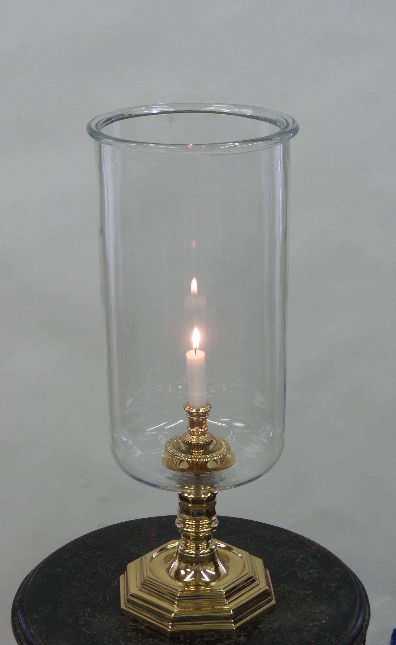 A Louis XIV style hurricane lamp with a polished brass base and handblown glass shade with a rolled edges. Please allow for up-to 2 weeks lead-time as well as for slight variations in dimensions due to each shade being handblown.