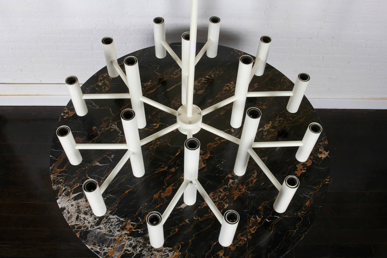 A circular light fixtire with 18 double socket modernist candle lights.
Formed in a Modernist grid of white powder coated metal with a very long stem
making it perfect for a stairwell.

Arm can also be cut to adjust to any room.