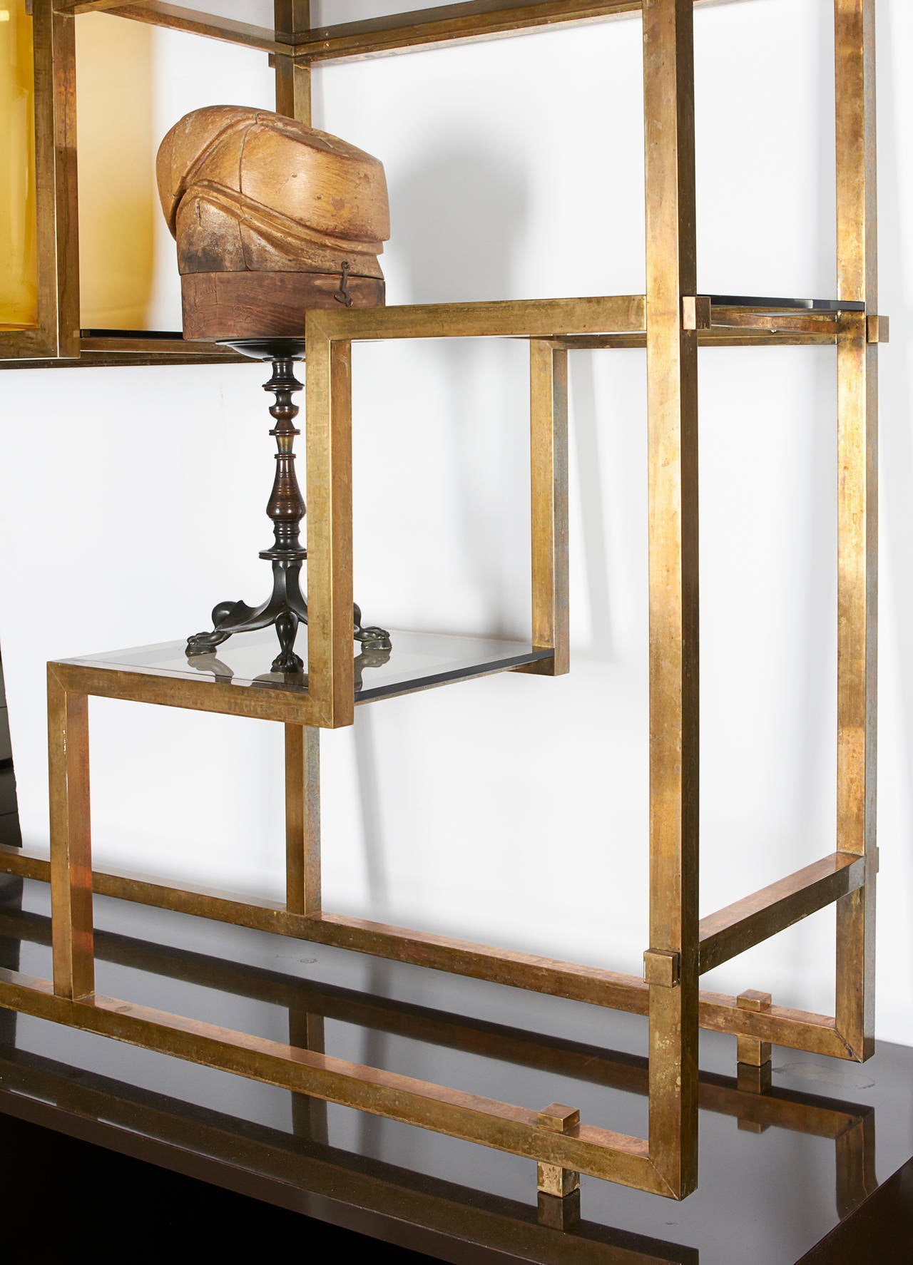 An etegere by Romeo Rega, solid antique brass shelving structure with smoked glass shelves sit atop a chocolate brown lacquered cabinet with four doors, interior shelves and an accent base made of antiqued brass.
Cabinet is finished on both sides