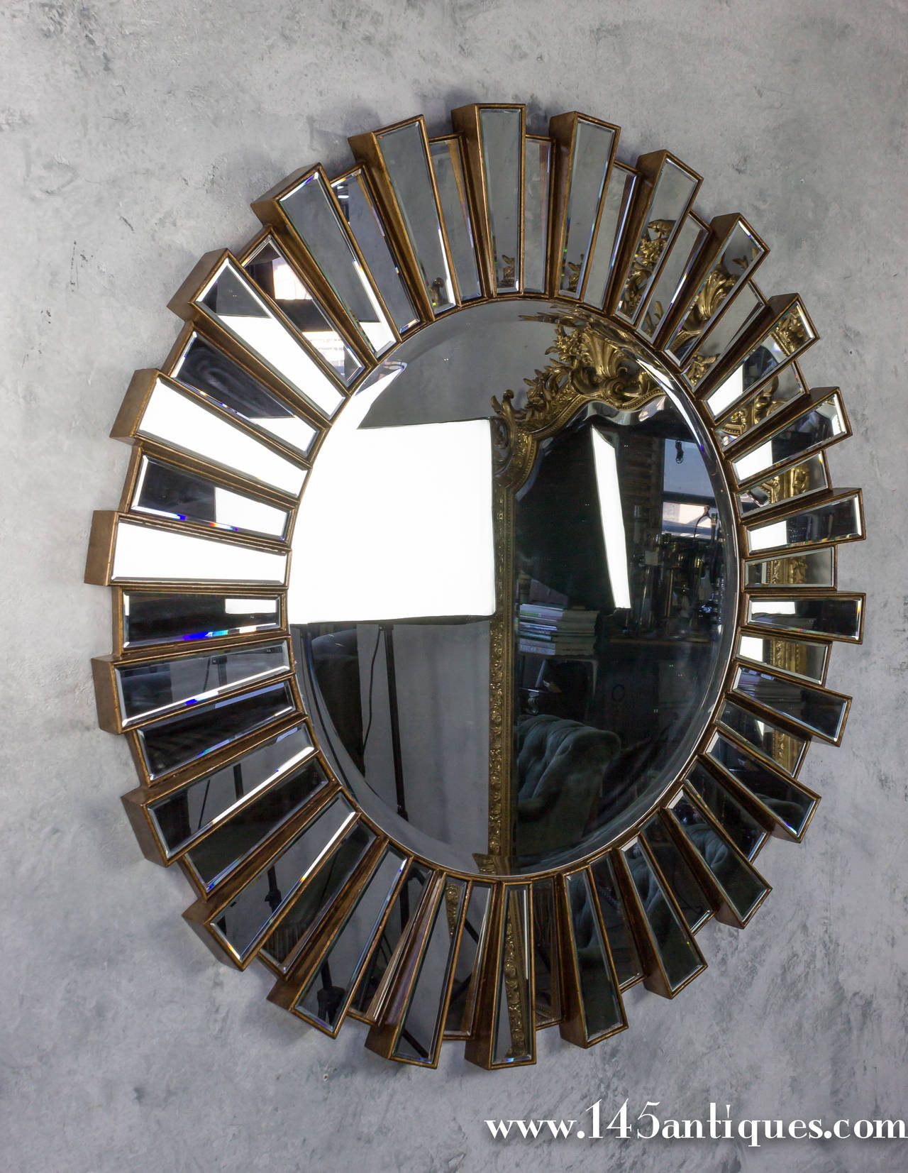Very large round sunburst mirror with interlocking tiers and bevel mirror in center and outer ring. Contemporary.