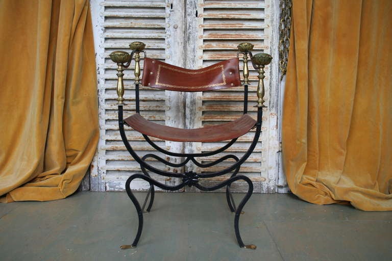 Italian iron campaign chair with brass detailing and leather upholstery.