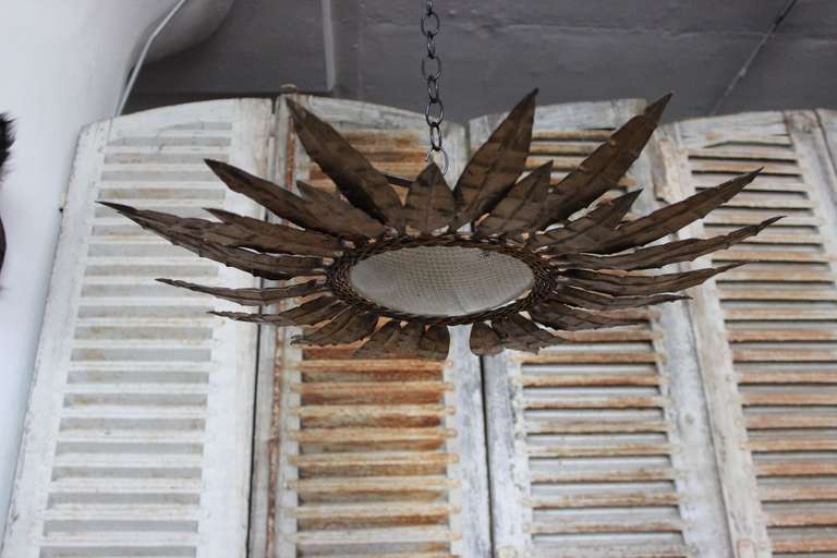 Gilt metal fixture with alternating leaves attached to triple braided center rings. 

UL wiring and matching canopy included in purchase price. Please allow 3 weeks for wiring. UPS shipping quote available on request.