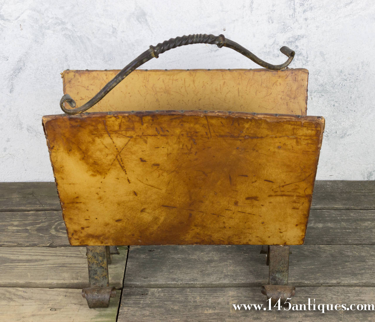 Spanish wrought iron  with leather covering magazine rack with decorative handle.