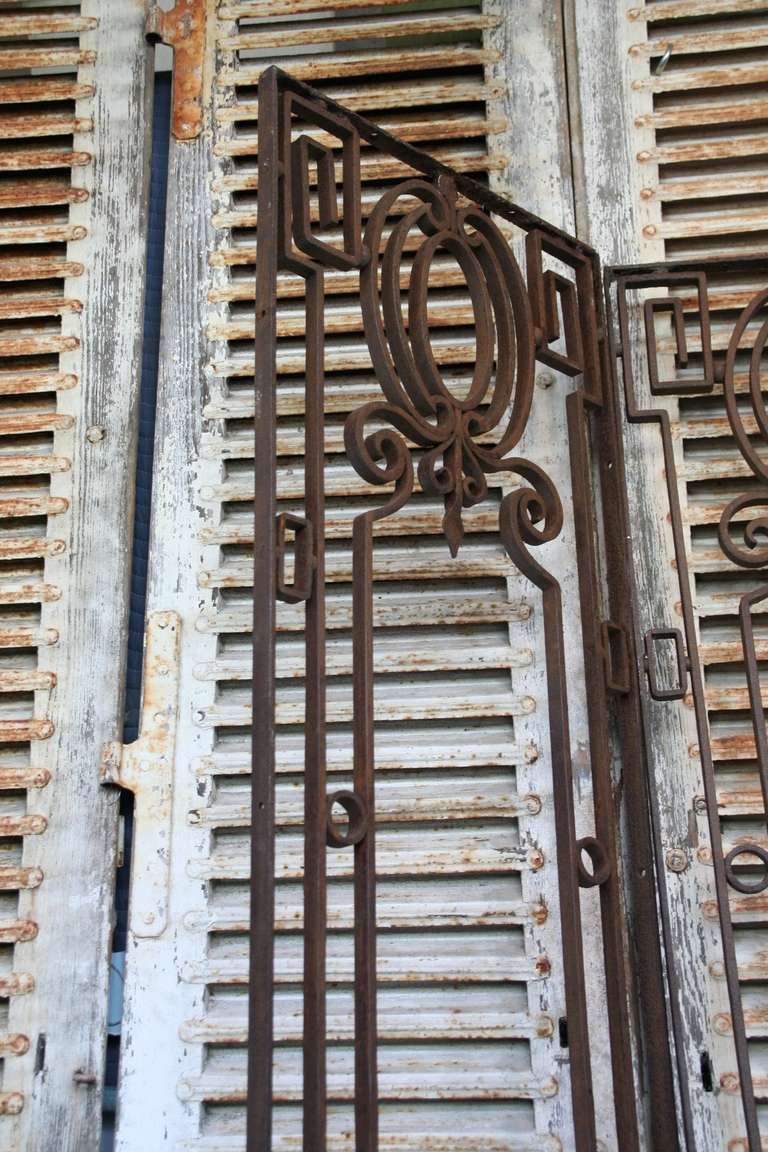  These elegant French door guards from the early 20th century are a true work of art. Made from wrought iron, they showcase intricate neoclassical details that are both beautiful and mesmerizing. The craftsmanship is impeccable, and they can be used