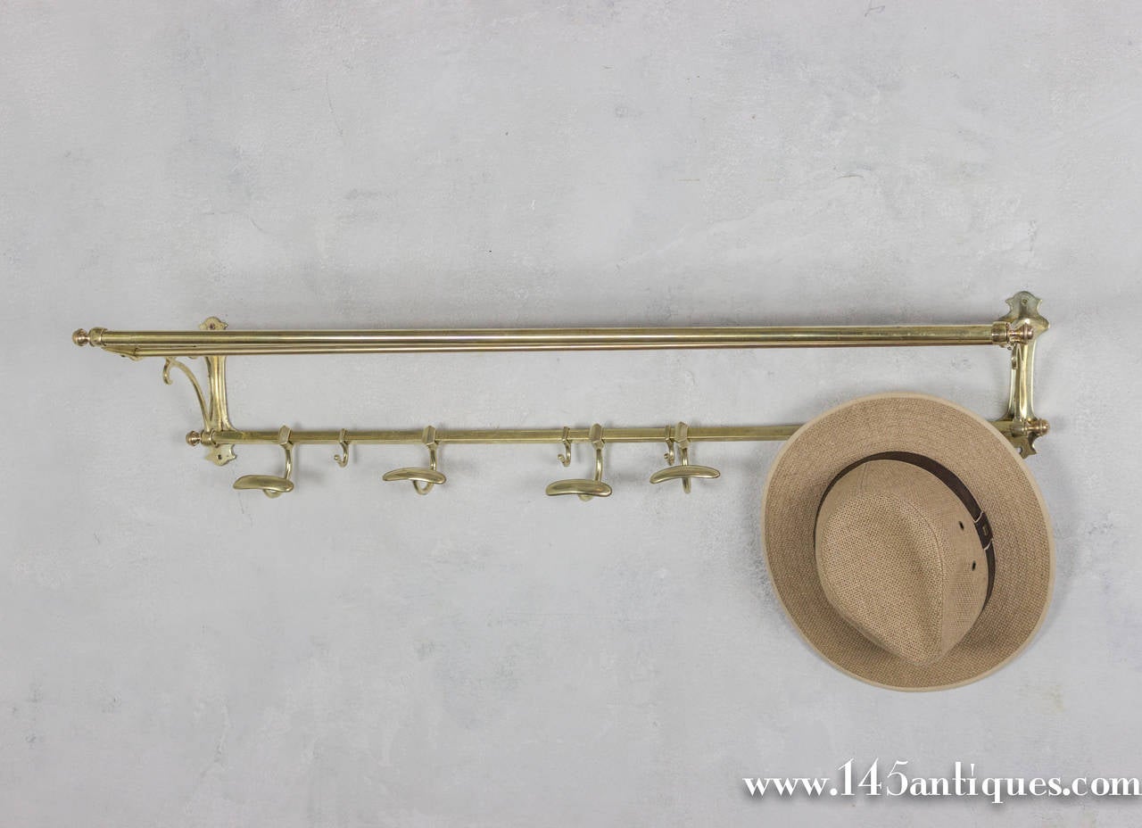 Early 20th century French brass coat rack with adjustable hooks and top hat rack.