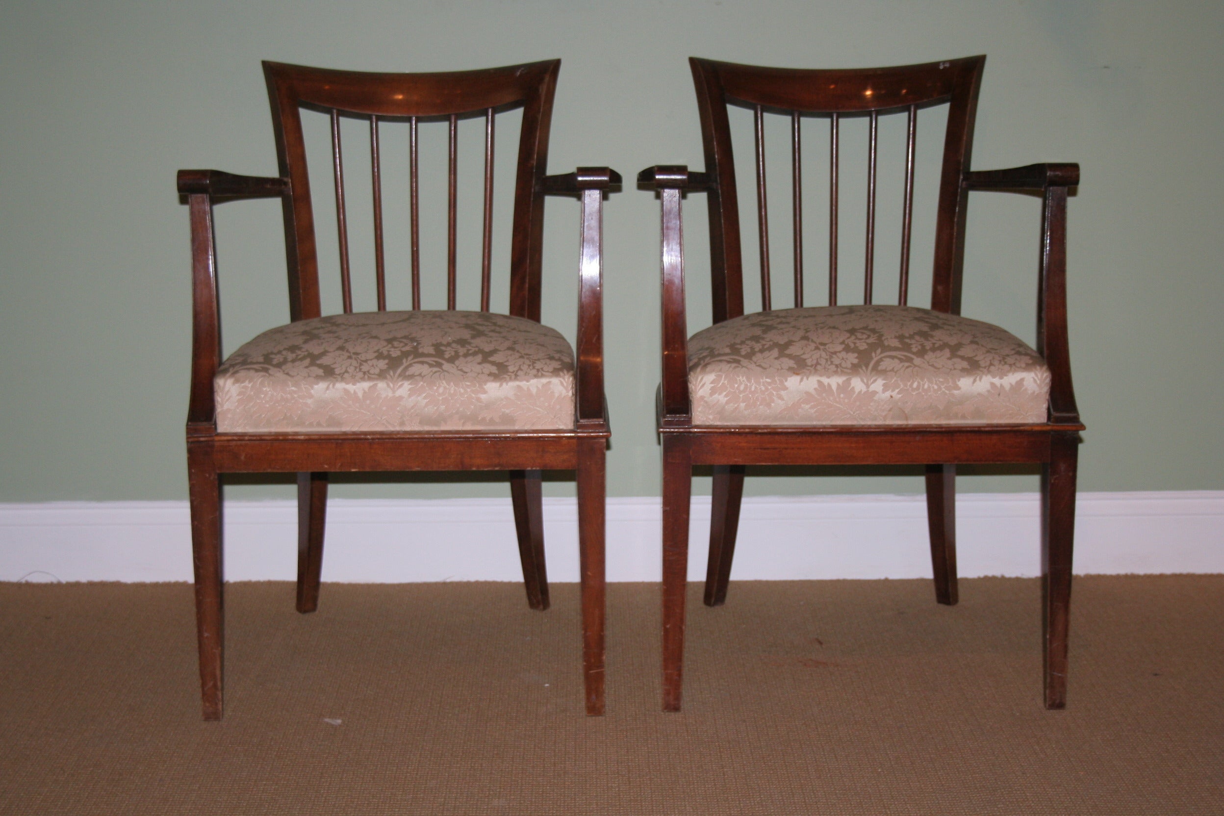 A lovely pair of 1950s French walnut armchairs with damask upholstery. Bring a touch of elegance to your home with this stunning pair of mid century French walnut armchairs. The sleek frames feature gently curved lines, while the cream floral