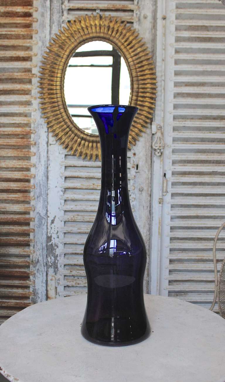 This is a tall Blenko vase in a dark amethyst.  