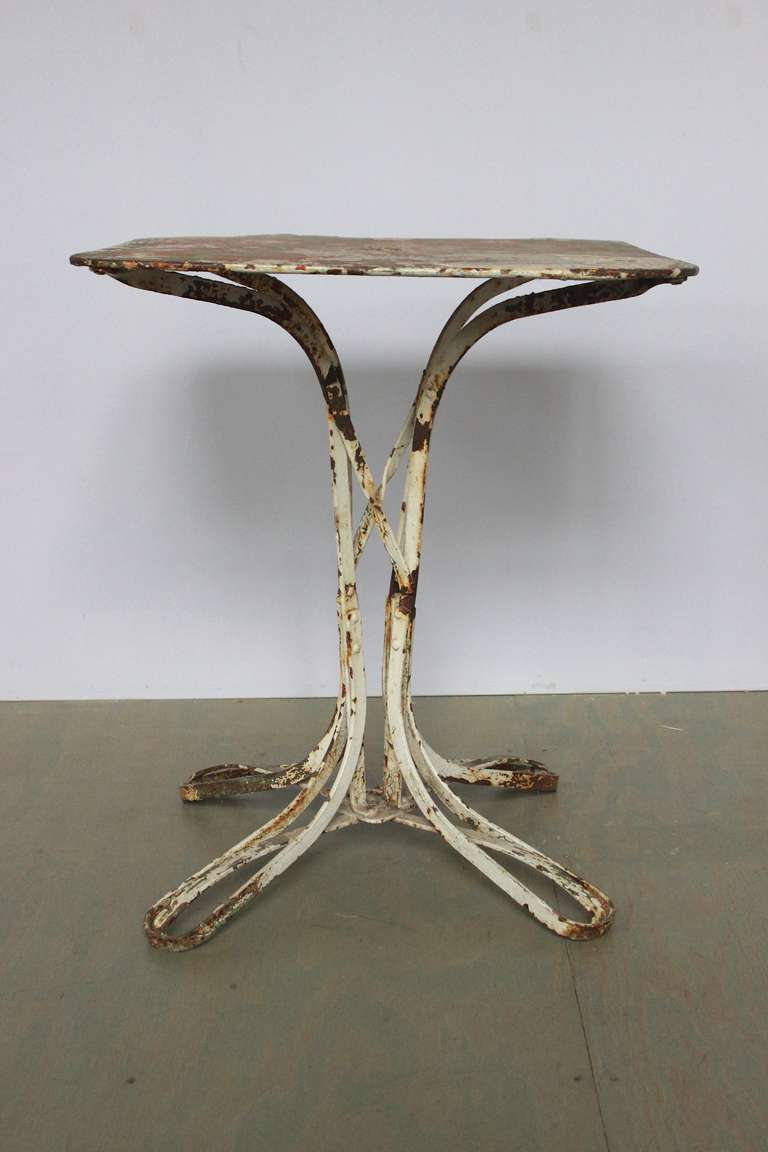 Small French garden table with wonderful patina. This piece is white with traces of green, red and rusted areas showing thru.   Circa 1910