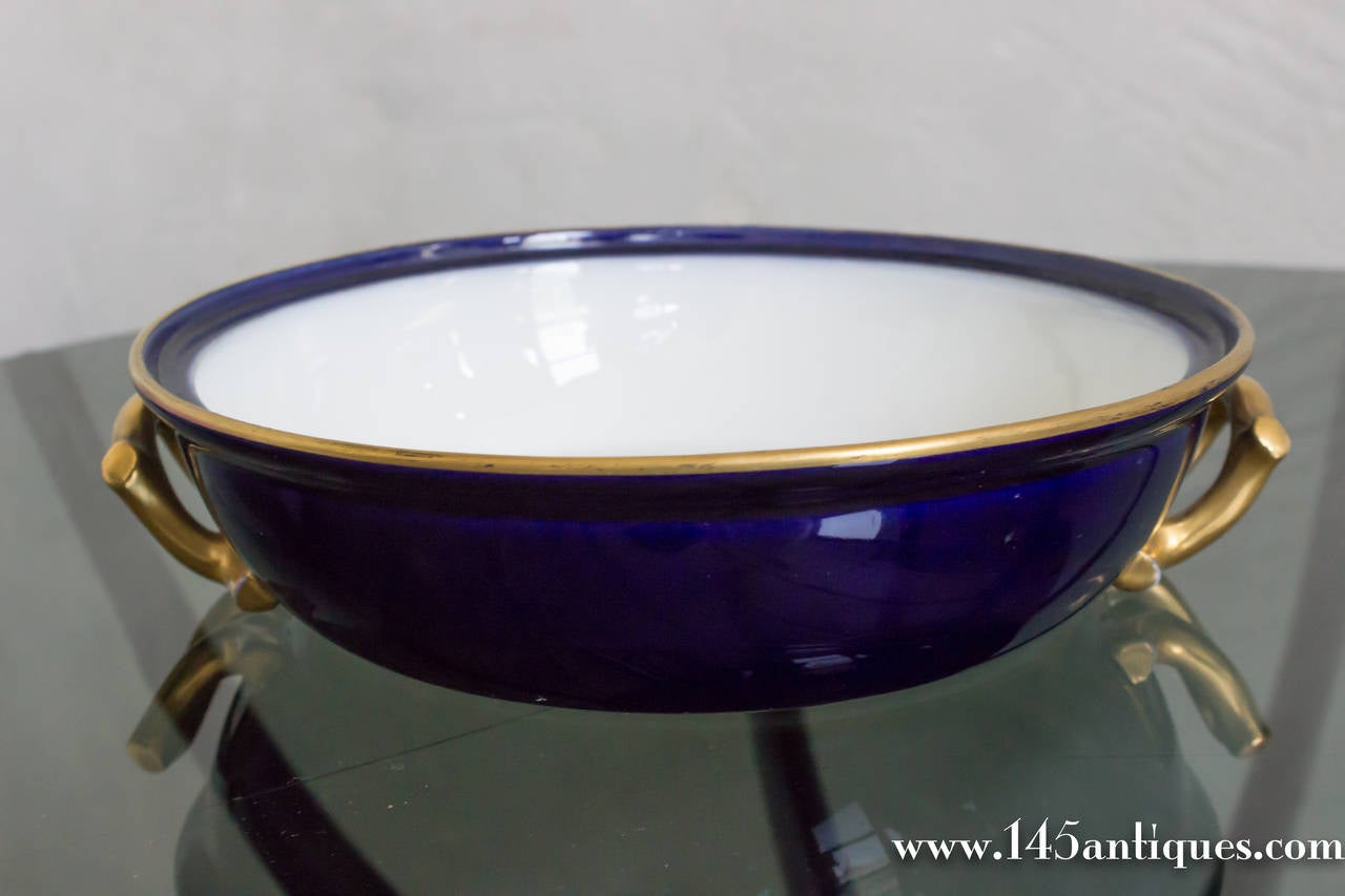 Elegant cobalt blue covered porcelian serving dish with glit handles and trim with white interior.