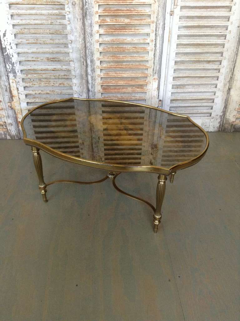 A very unusual and top quality coffee table made of various  bronze, brass , and reverse painted gold mirror. In the style of Baques or Maison Charles, circa 1940.   The  table is in excellent condition, some slight signs of age on the plating.