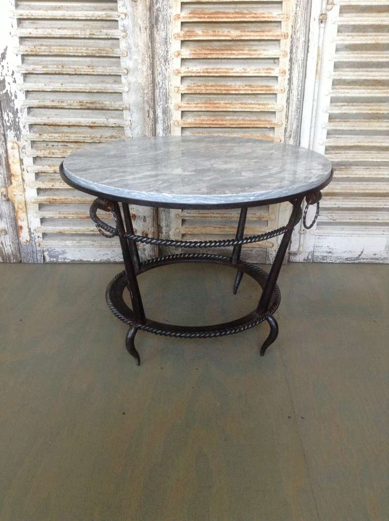 Wrought iron coffee table with braided iron detail and a light grey marble.