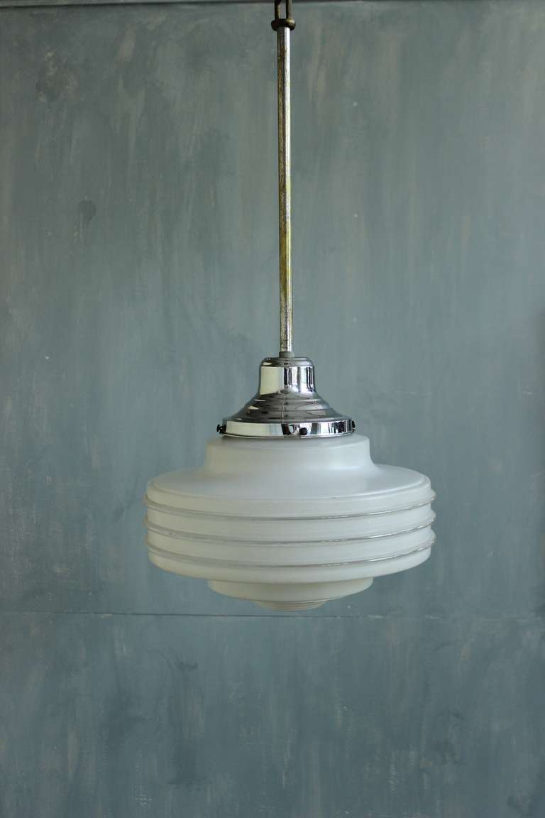 Questo straordinario apparecchio da soffitto sospeso francese degli anni '30 presenta un'elegante fusione di bande di vetro smerigliato e trasparente. Questo gioiello d'epoca è in buone condizioni e presenta solo lievi segni di usura, coerenti con