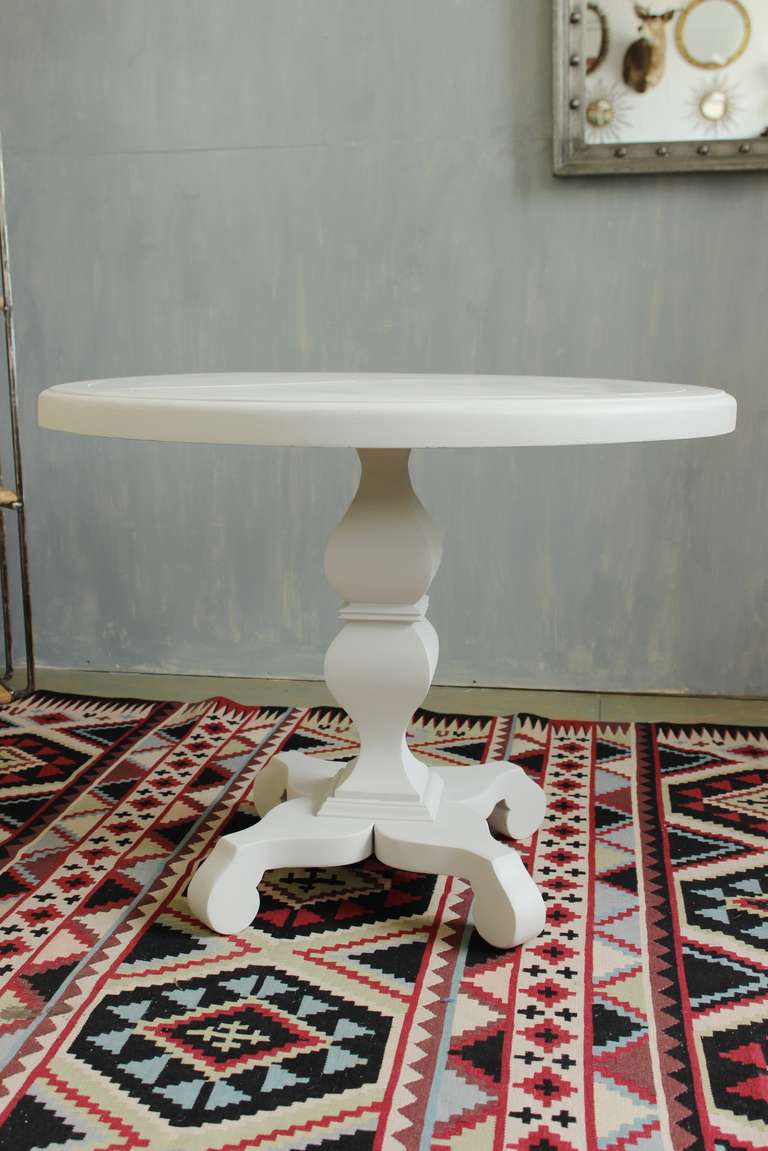 Modern round center table, painted creamy off-white.