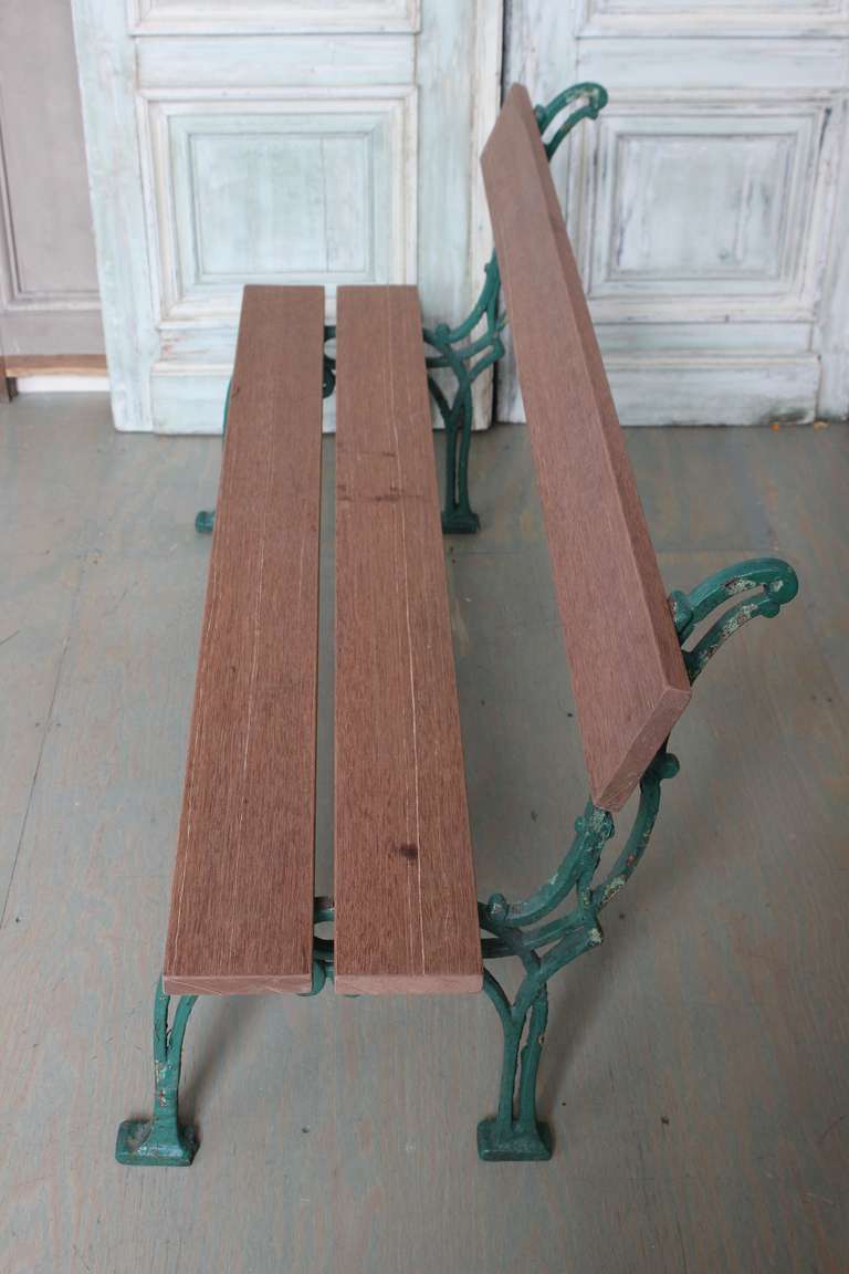 The green cast iron legs are French early 20th century. The solid mahogany seat and back planks are recent. By nature mahogany will weather very nicely, but can be easily painted.

This price of this item has been reduced. This is the final net
