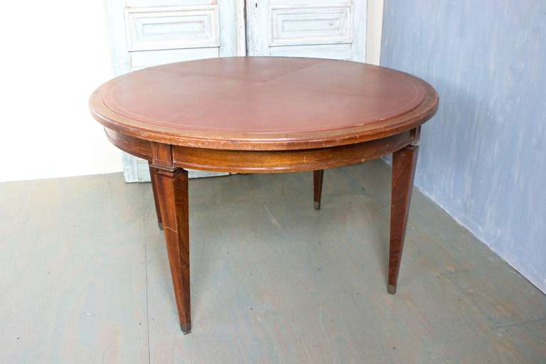 French 1940s mahogany card table with leather inset that had gold tooling border. The legs have brass sabot. This piece is need of polishing. It is sold in 