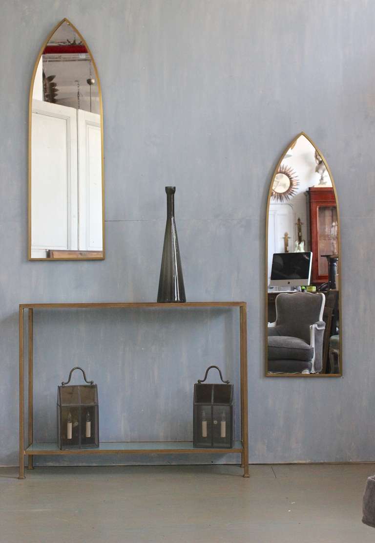 Pair of Mid-Century brass framed mirrors in an arch design.