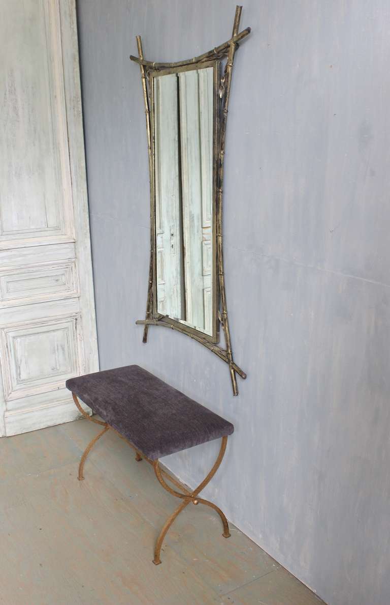 French gilt iron mirror in a bamboo stylized frame with corner leaf decoration. The beveled glass is recent.