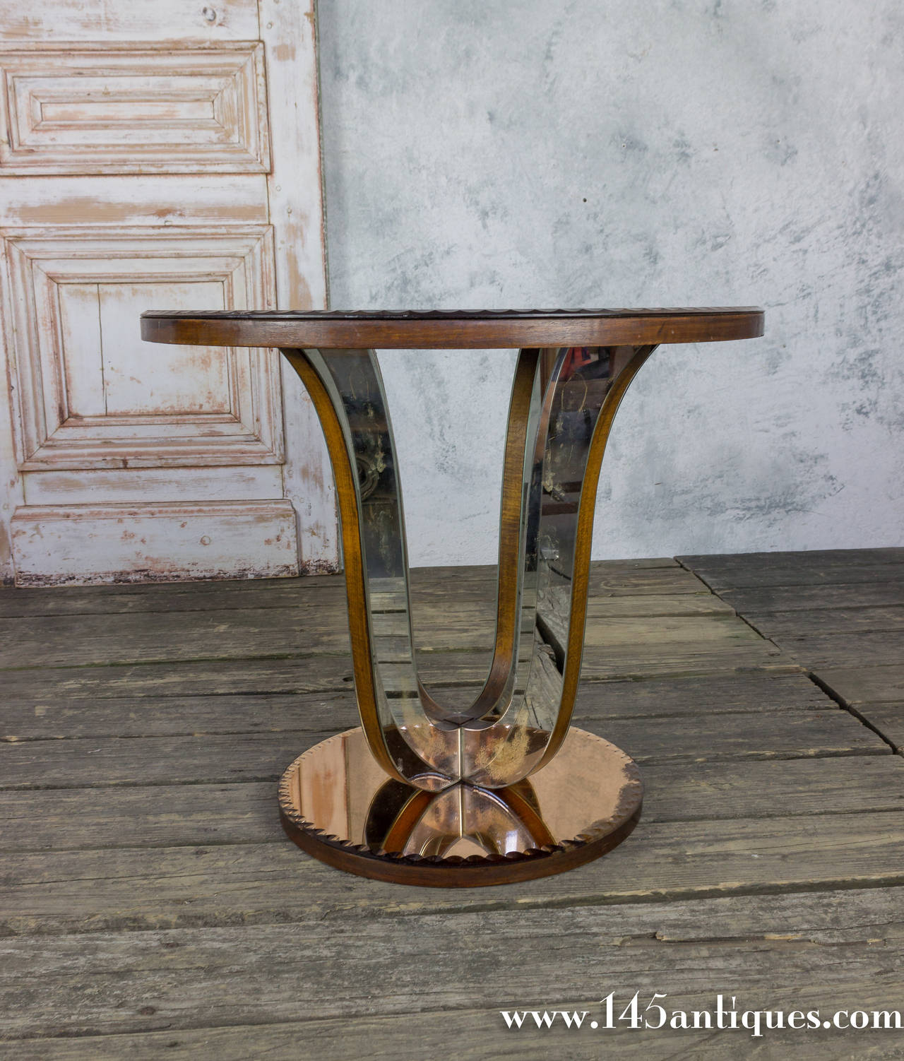 French 1940s mirrored end table with mahogany trim. The rose colored mirror is water beveled around the top and bottom mirror. There is aging marks on some of the pieces of mirrors, appropriate with the age the table.