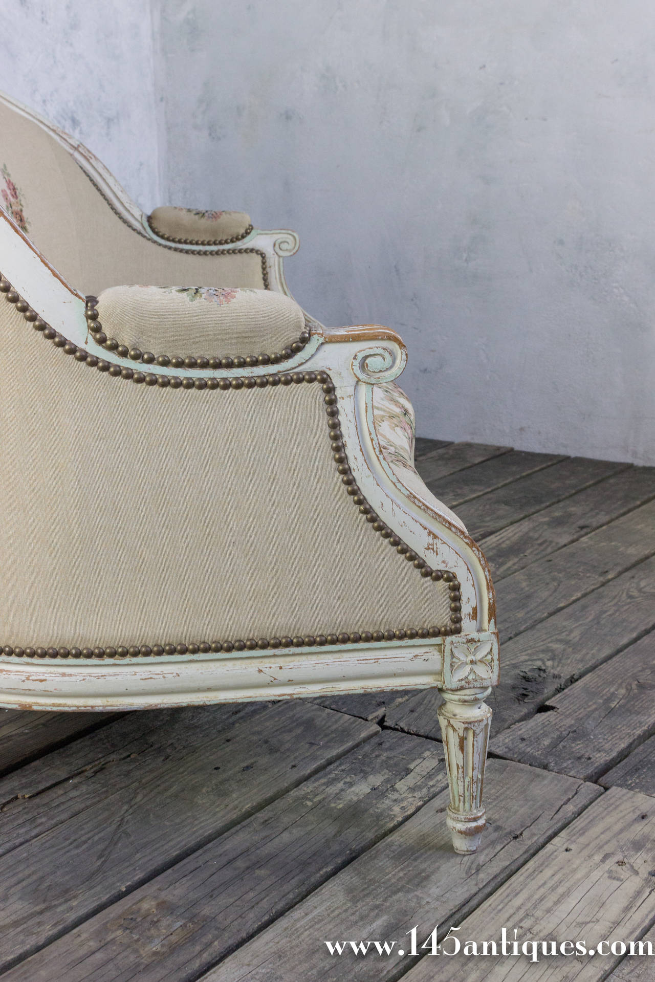 This settee has its original whitewashed patinated finished frame with carved decorations and fluted legs. The fabric is a petit point floral design and in excellent condition. This settee is part of a larger 