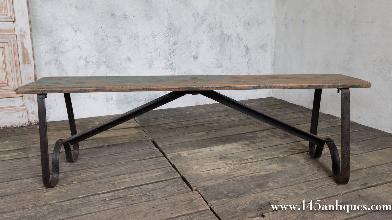 French 1920s Industrial wood bench with curved iron base.