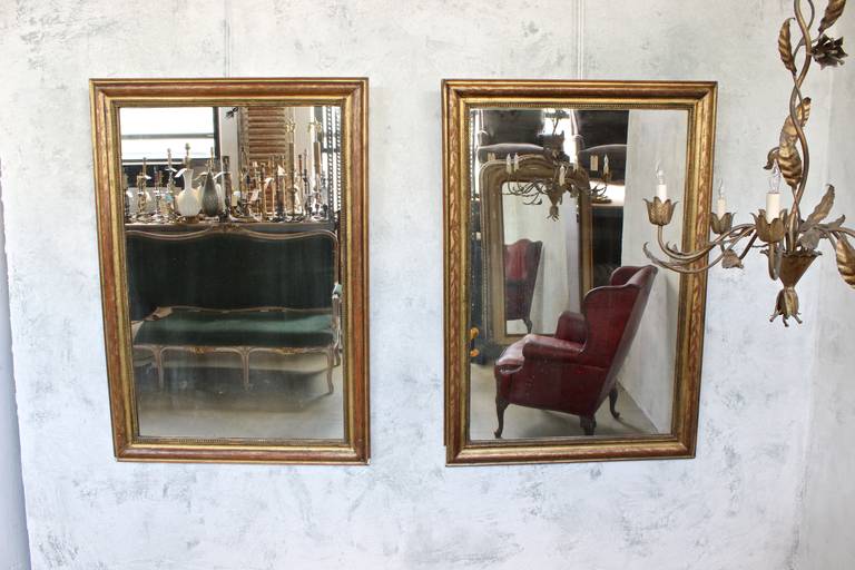 Pair of 19th century Louis Phillipe mirrors with aged gilt frames. The mirrors are of period with some aging.
