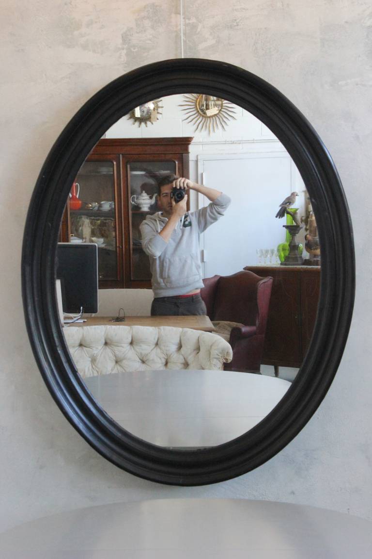 Large Napoleon III oval mirror with black painted frame.