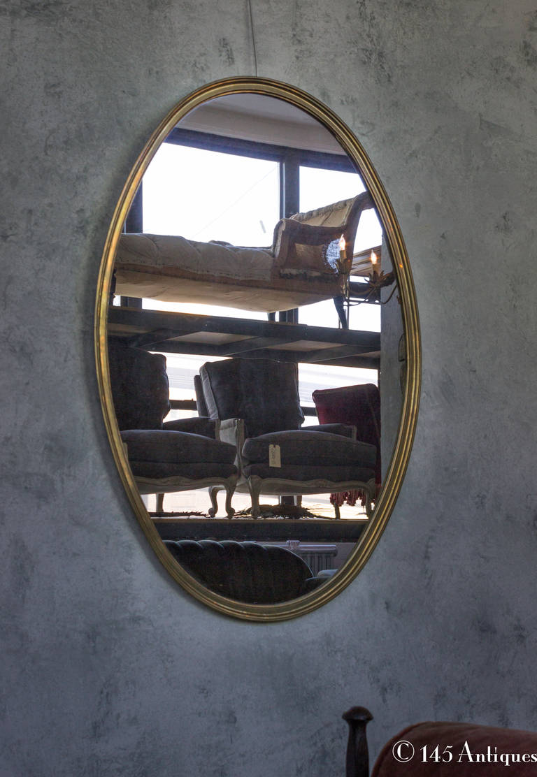 1950's French vintage mirror in a brass frame. This mirror has an asymmetrical oval shape with much character.