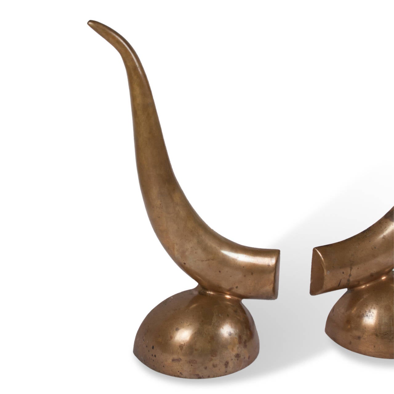 Pair of solid bronze chenets, each of a tapered horn-like form, resting on a semispherical base, French, 1940s. Measures: 4 in. D, 7 in. W, 18 in. H. 