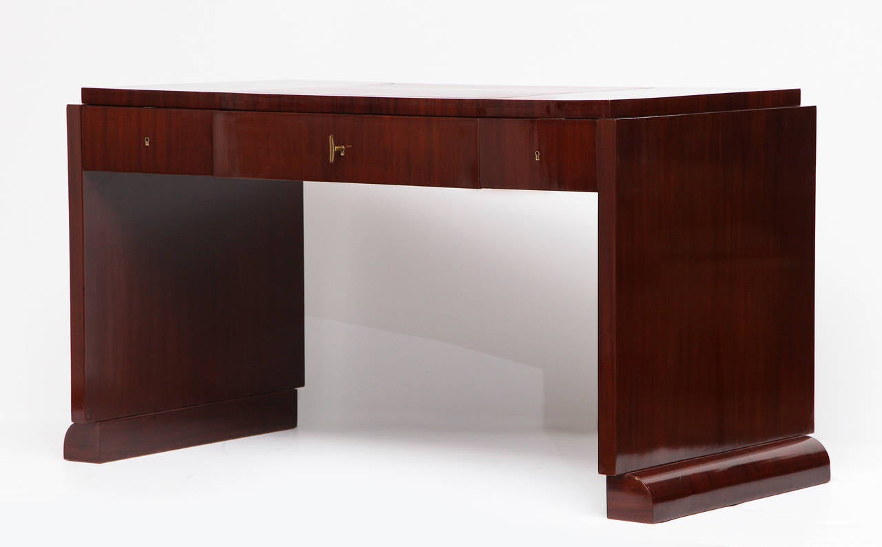Modernist desk with with three drawers in mahogany, leather top and bronze details