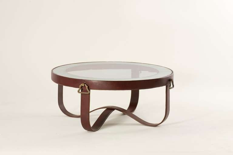 A rare coffee table by Jacques Adnet  (1901-1984) with original bordeaux leather, bronze ornaments and partially mirrored glass top

A similar table is shown in a 1951 drawing by Adnet for the oceanliner Ferdinand de Lesseps, Musée des Arts