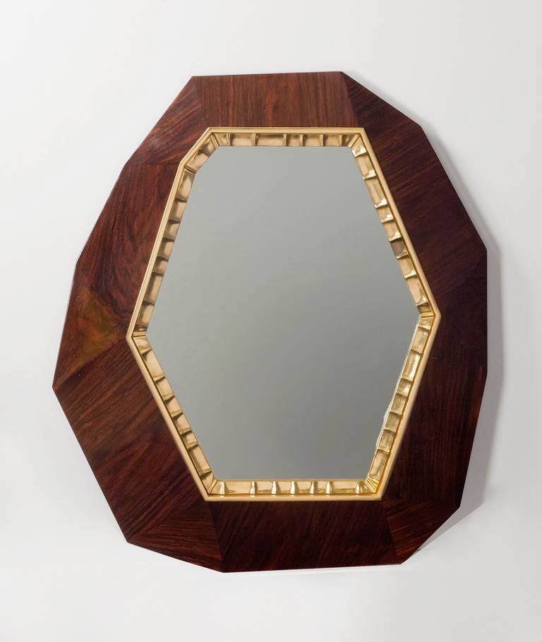 Lucy is a hexagonal mirror set, like a jewel, in a facetted plaque (either of noir doré marble, brown Emperador marble, or polished Royal Oak), and bordered by thin ornamental patinated bronze trim.

Edition of 20.
Stamped: Achille Salvagni Atelier.