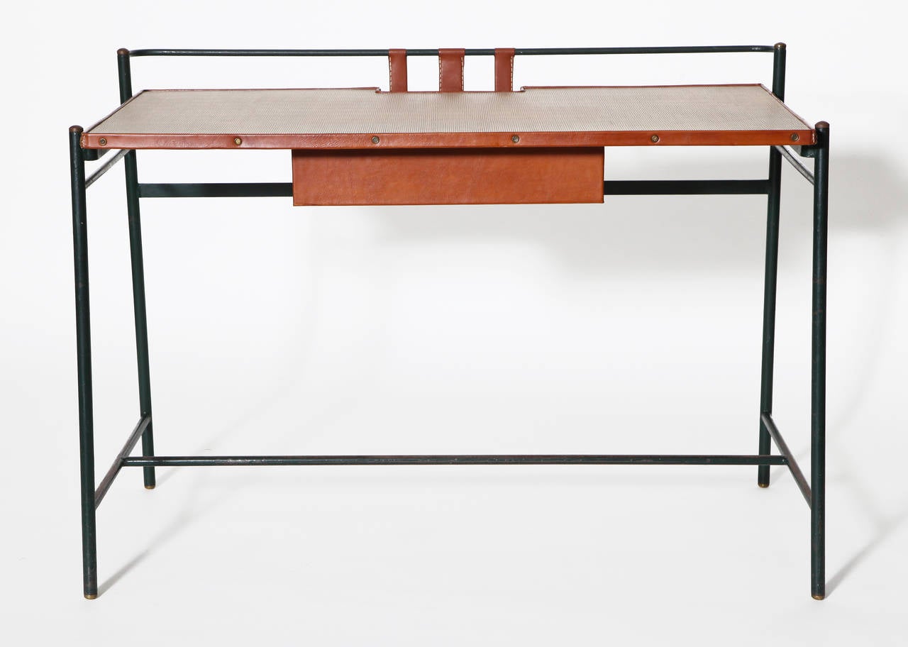 Leather and metal desk with rattan top by Jacques Adnet.

For illustrations of a similar model, see:
Le Decor d’aujourd’hui, no. 69. 1952.
Mobilier et De´coration, no. 9. December 1954. 406.