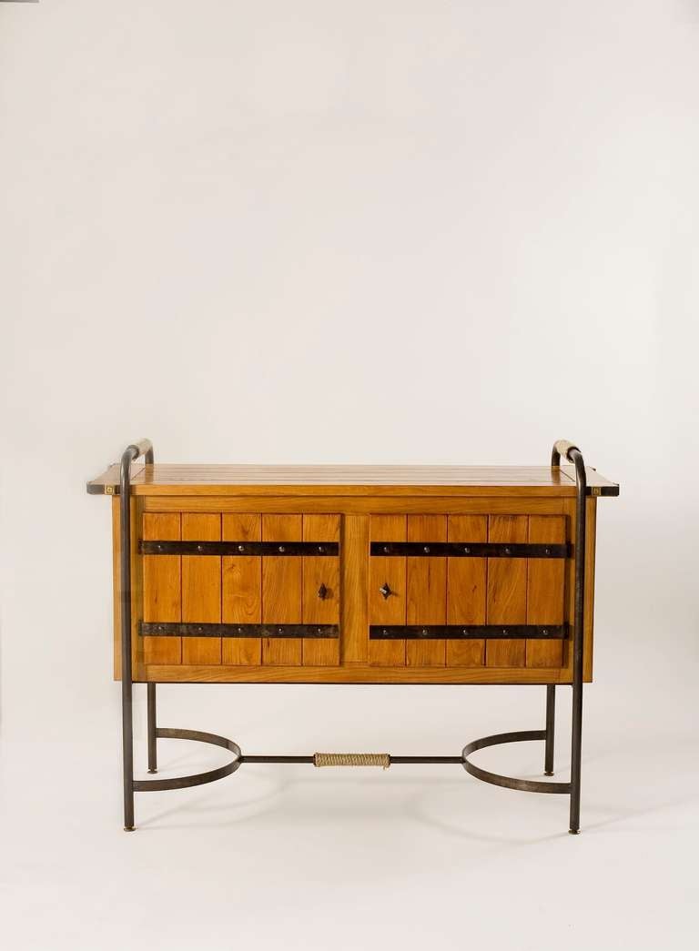 A rare two door cabinet by Jacques Adnet in oak with a black wrought iron frame and rope details.